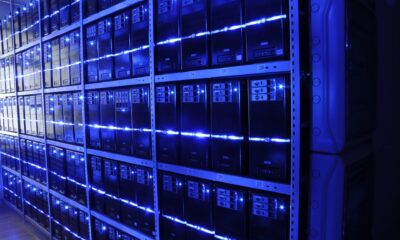 Allée de baies de serveurs éclairées en bleu dans un data center
